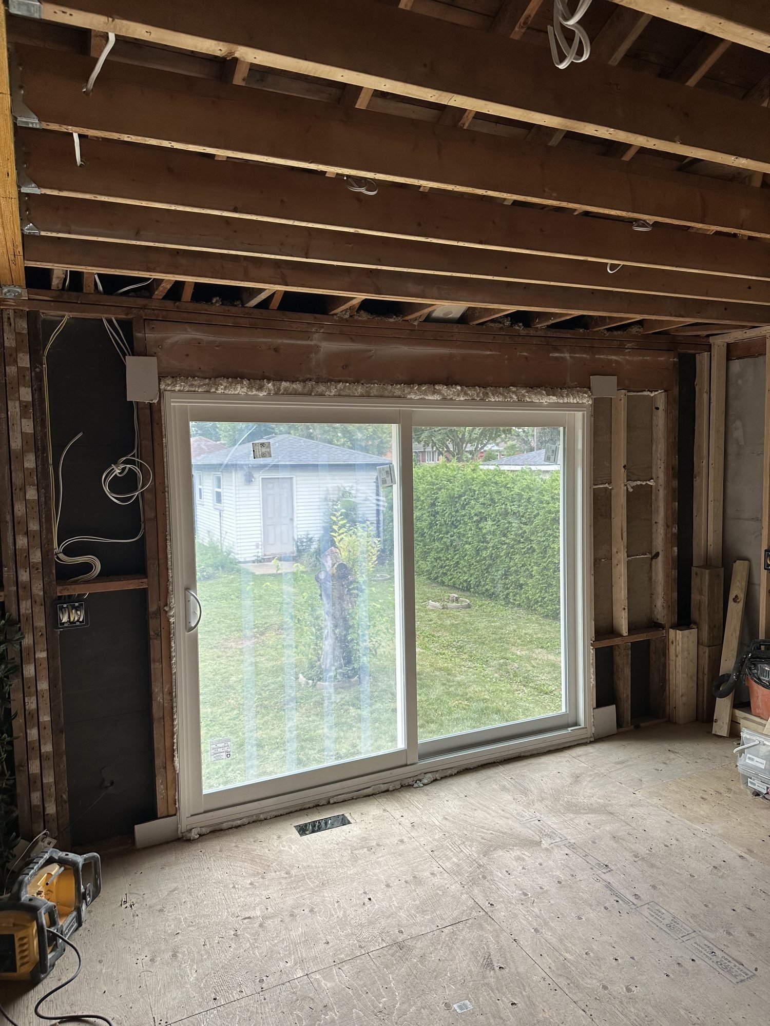 Wide white sliding patio door installed during an interior renovation