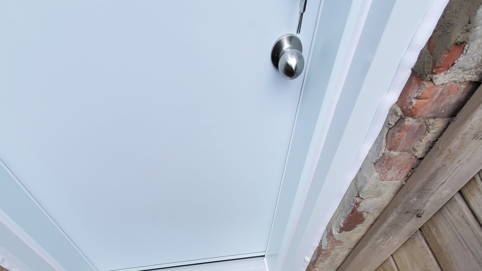White exterior door and threshold above a concrete lower-level landing