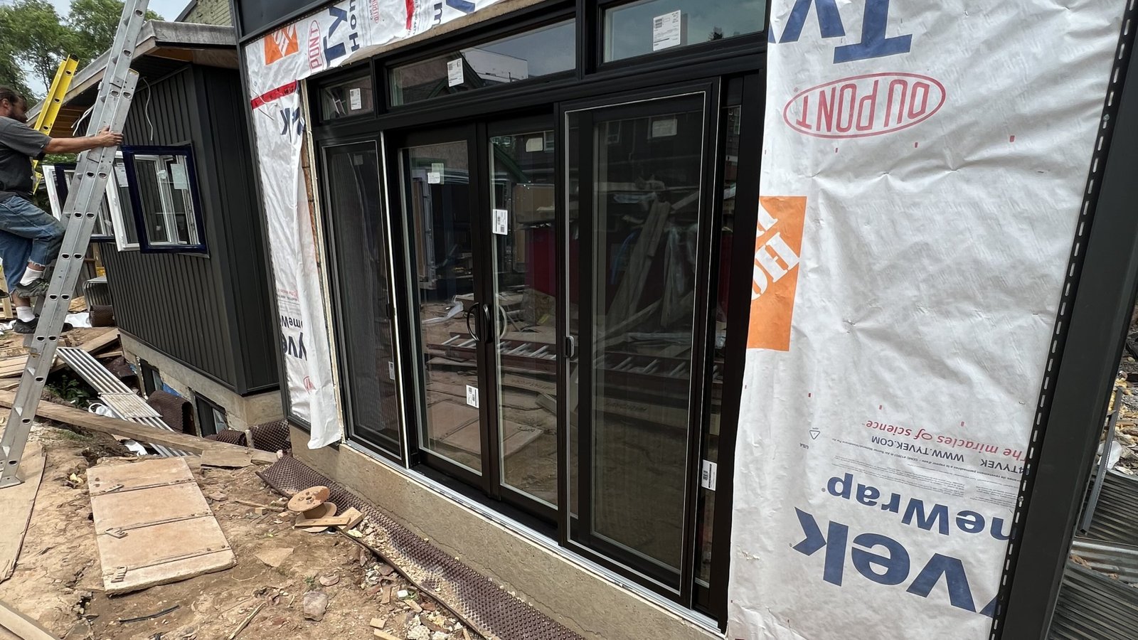 Black glazed patio door system being installed in a home addition