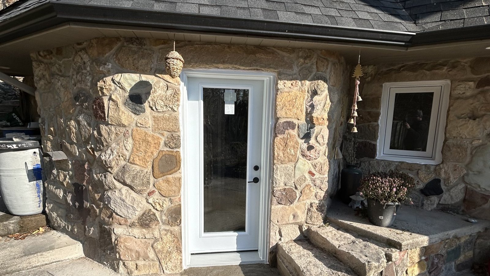 White full-glass exterior door and window set into a stone wall