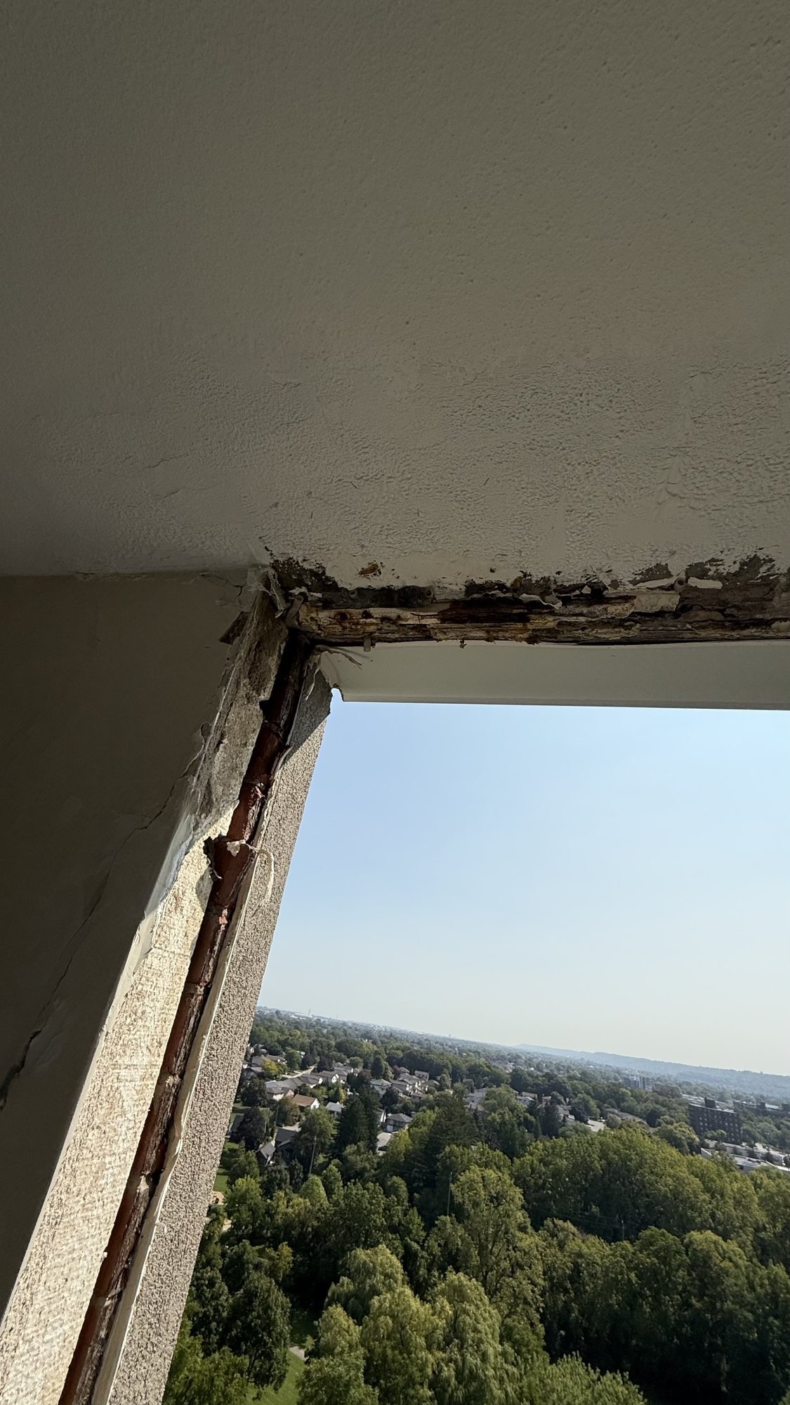 High-rise window opening stripped to exposed concrete during replacement work